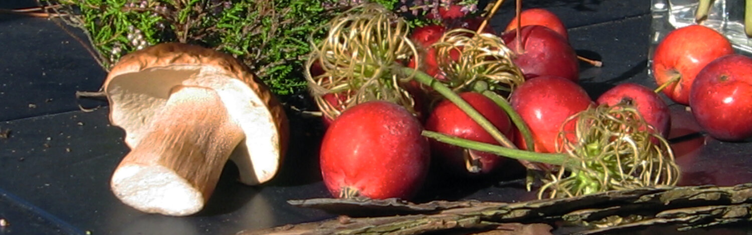 Décoration d’automne typique sur une table : pommes, un champignon, bruyère