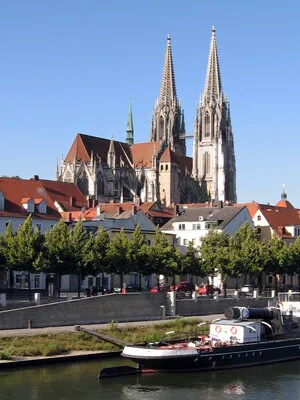 Cathédrale de Ratisbonne au-dessus de la vieille ville, avec le Danube et un bateau au premier plan
