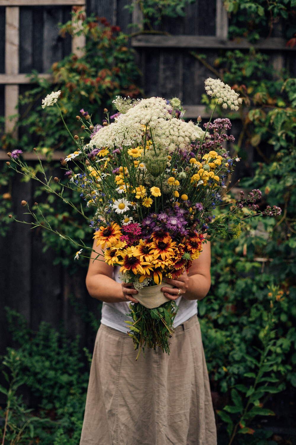 Femme avec un grand bouquet de fleurs sauvages fait maison
