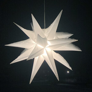Étoile de l'Avent blanche lumineuse dans l'obscurité