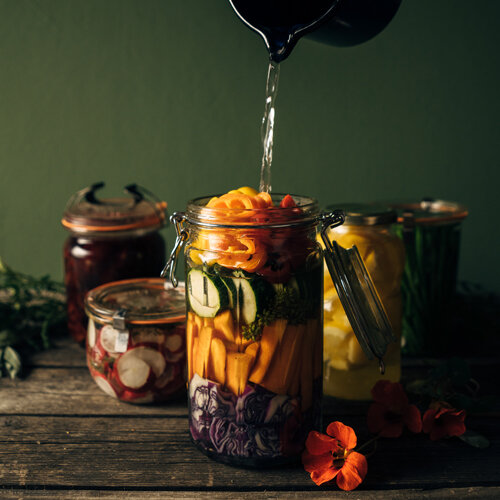 Légumes à fermenter : carottes, courgette et chou rouge en bocal, arrosés de saumure