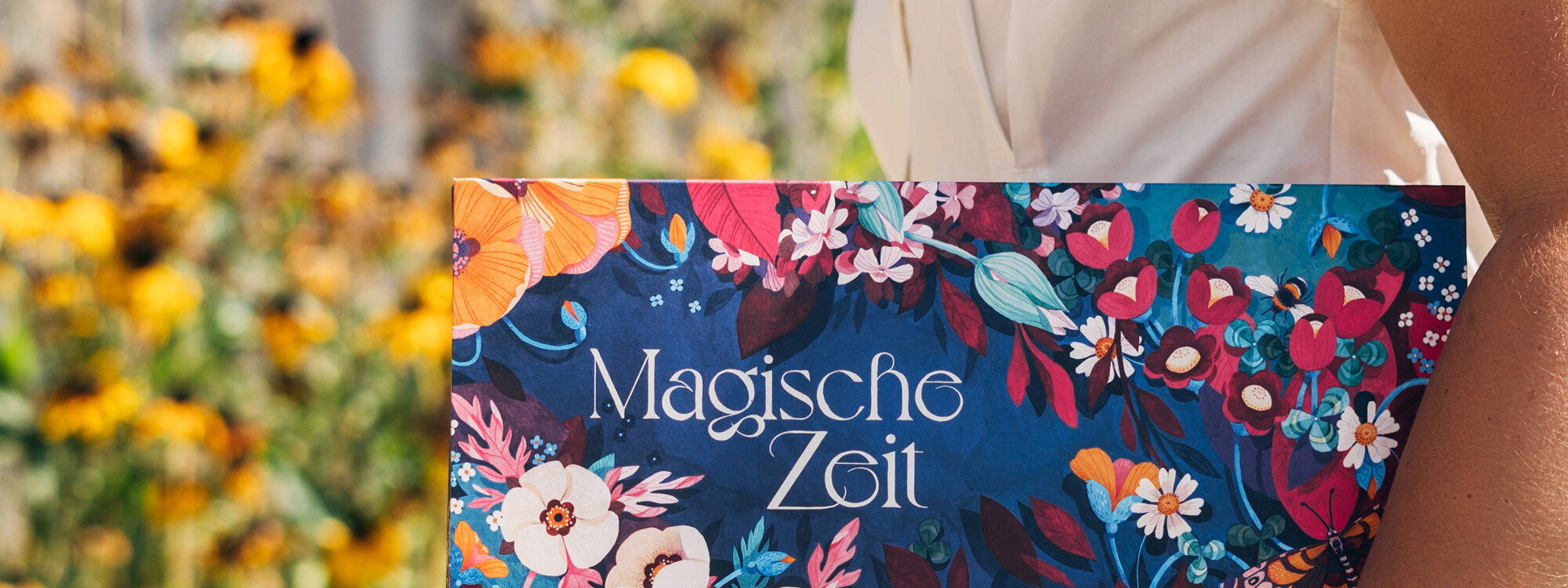 Boîte du calendrier de l'Avent bio « Moments magiques » L’ivresse des fleurs sauvages devant des fleurs d'été jaunes